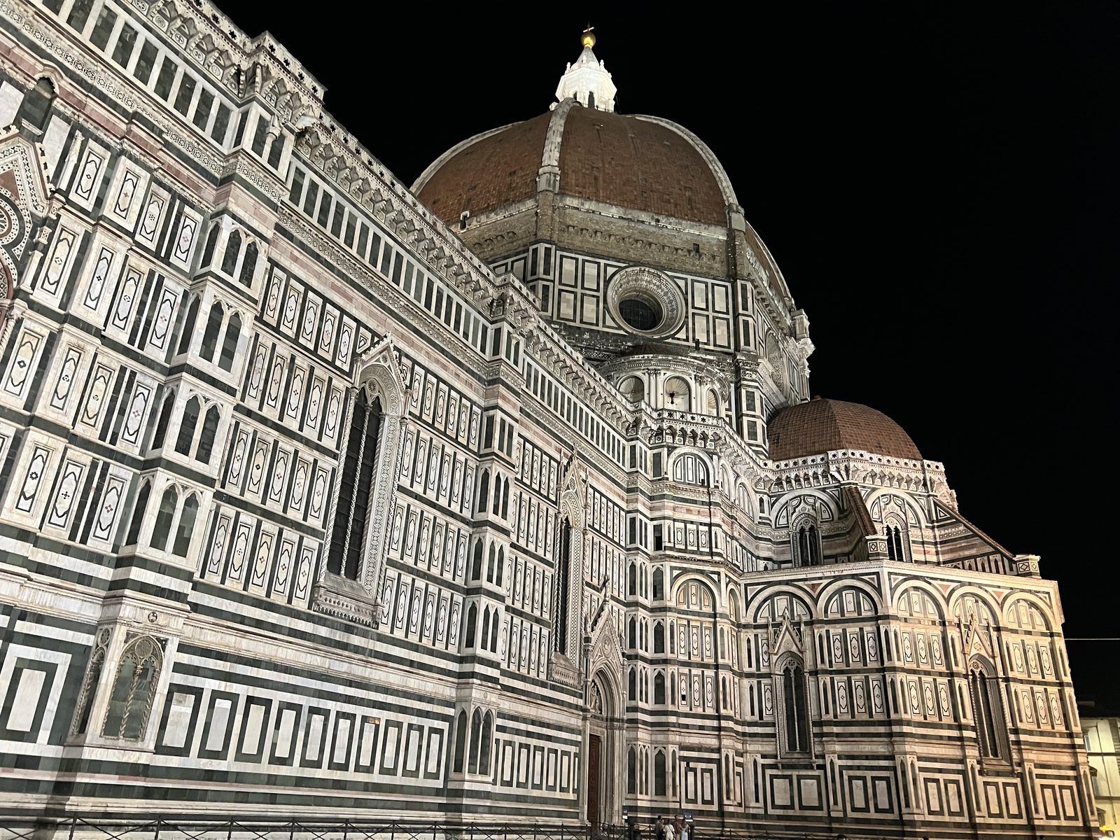 Brunelleschi's dome on the Cattedrale di Santa Maria del Fiore in Florence, photographed at night with the green and white marble facade illuminated