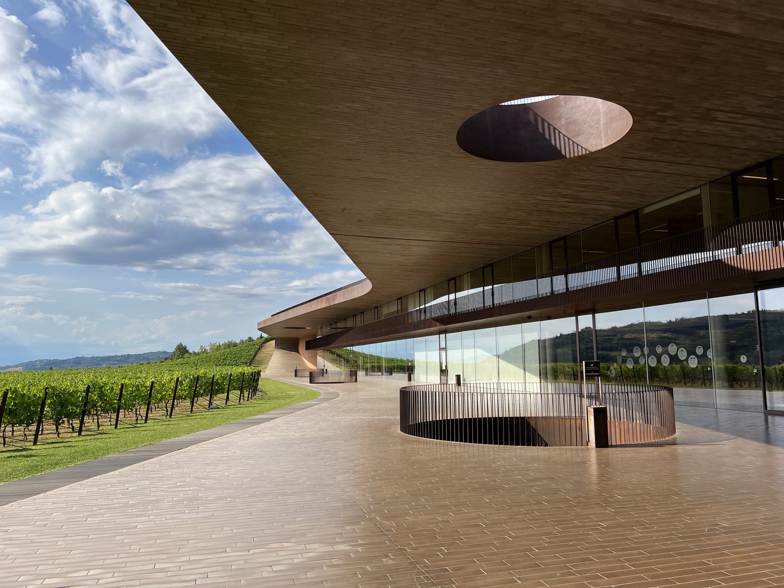 The cantilevered roof of the Antinori nel Chianti Classico winery, with vineyards to the left and a circular skylight cut into the ceiling